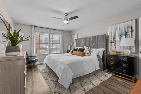 A bedroom with a large bed and a ceiling fan.