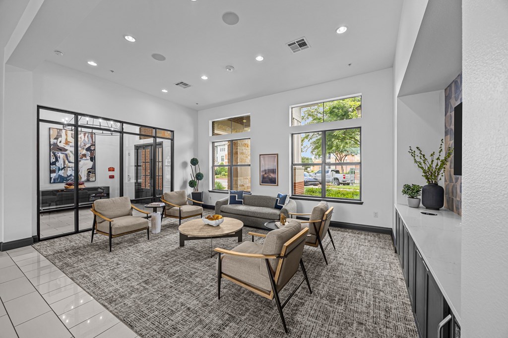 A spacious waiting room with a grey carpet and wooden furniture.