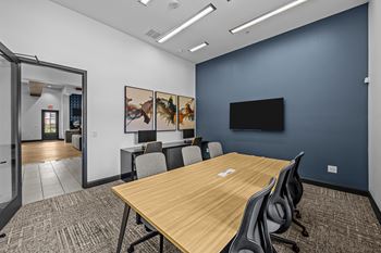 A conference room with a long table and chairs.