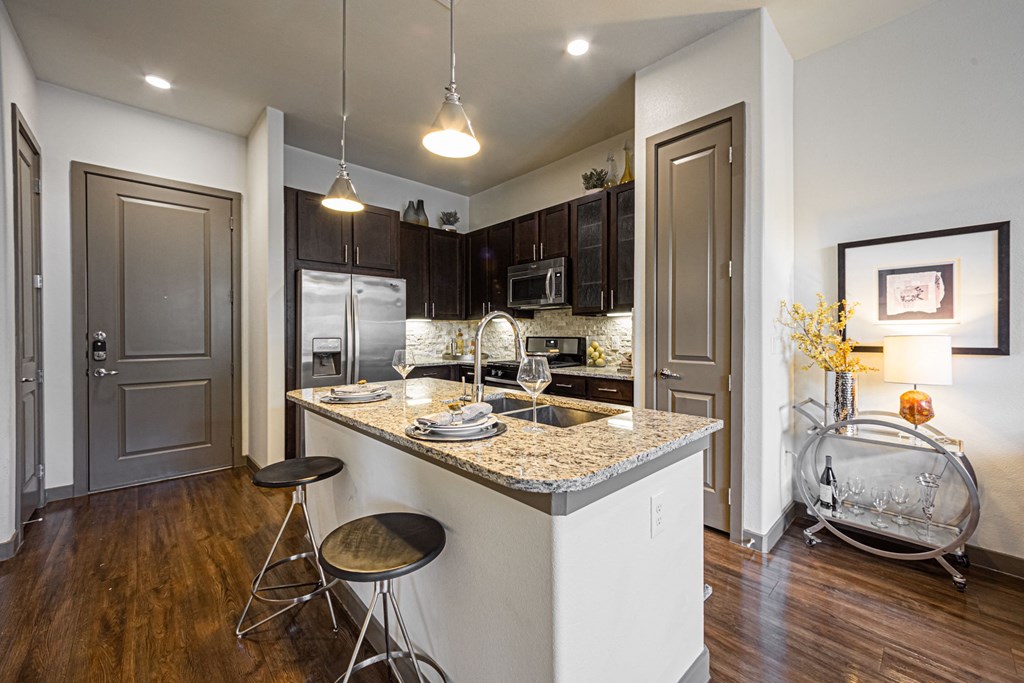 a kitchen with an island and stools in front of a counter top