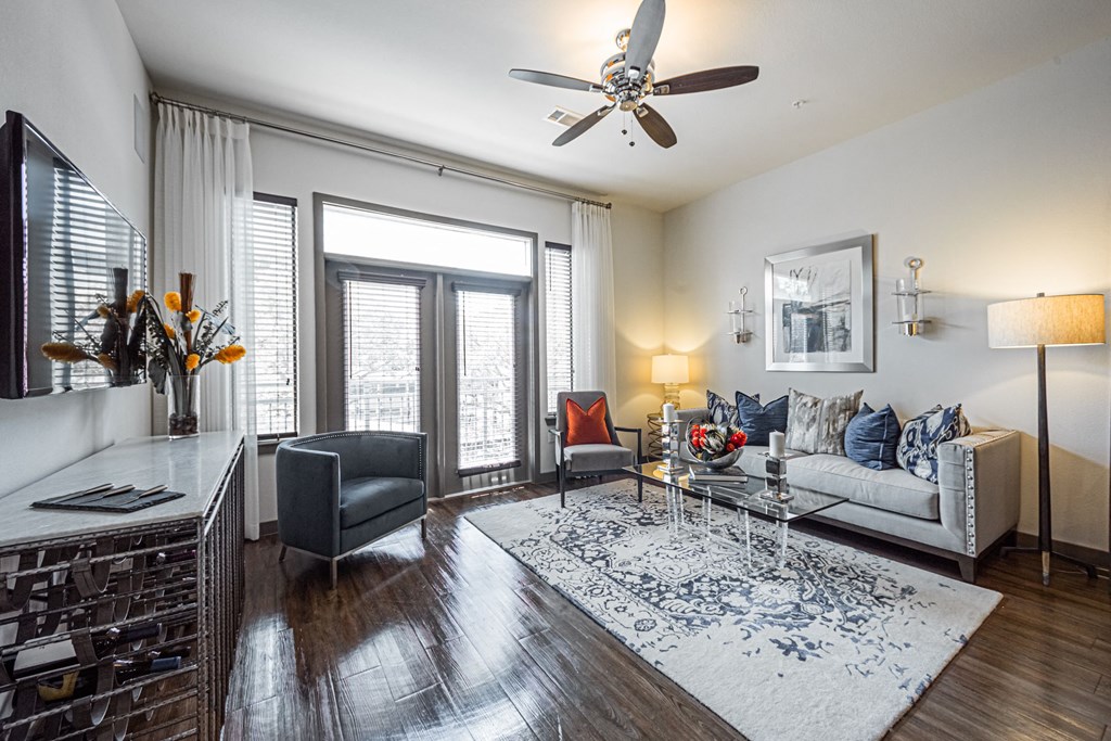A living room with a grey sofa, a coffee table, and a ceiling fan.