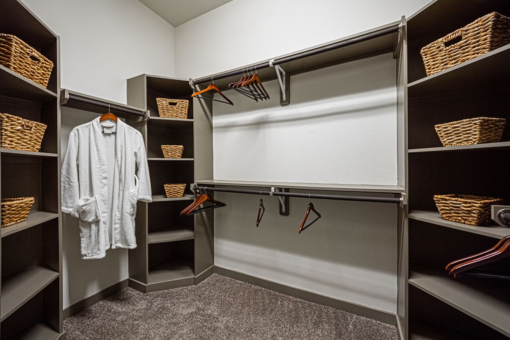 A white shirt is hanging on a hanger in a closet.