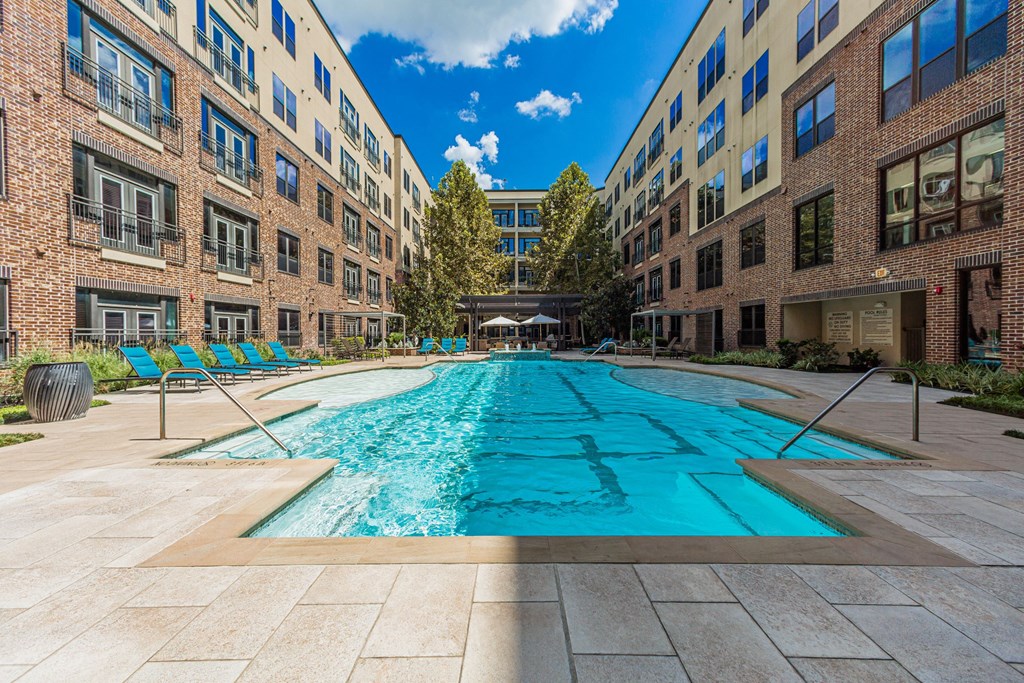 an apartment with a swimming pool in the middle of two apartment buildings
