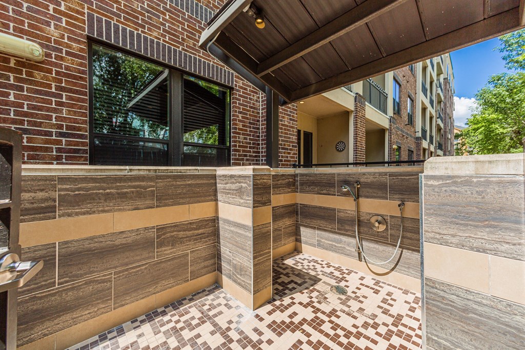 A bathroom with a tiled floor and a shower area.