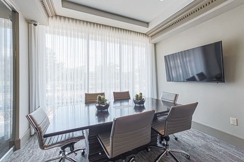 A conference room with a large table and chairs.