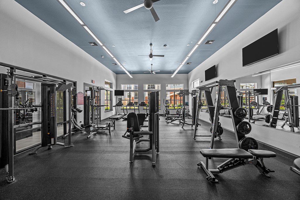 A gym with a variety of equipment including weights and machines.