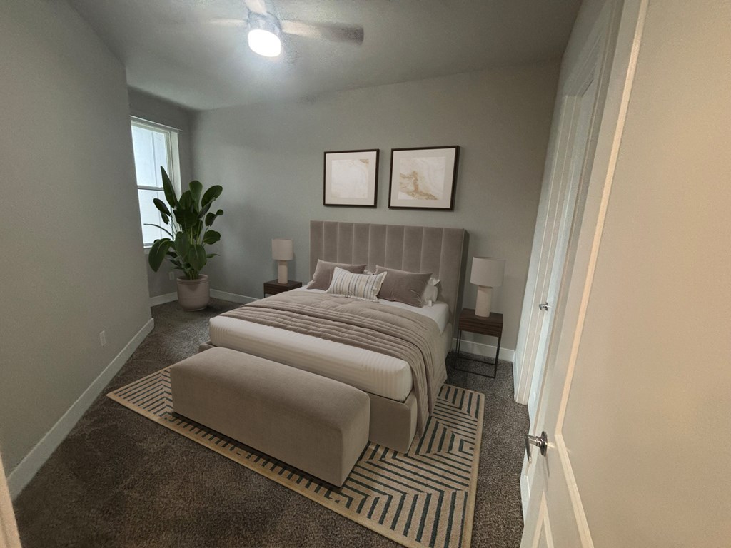 A bedroom with two beds and a plant.