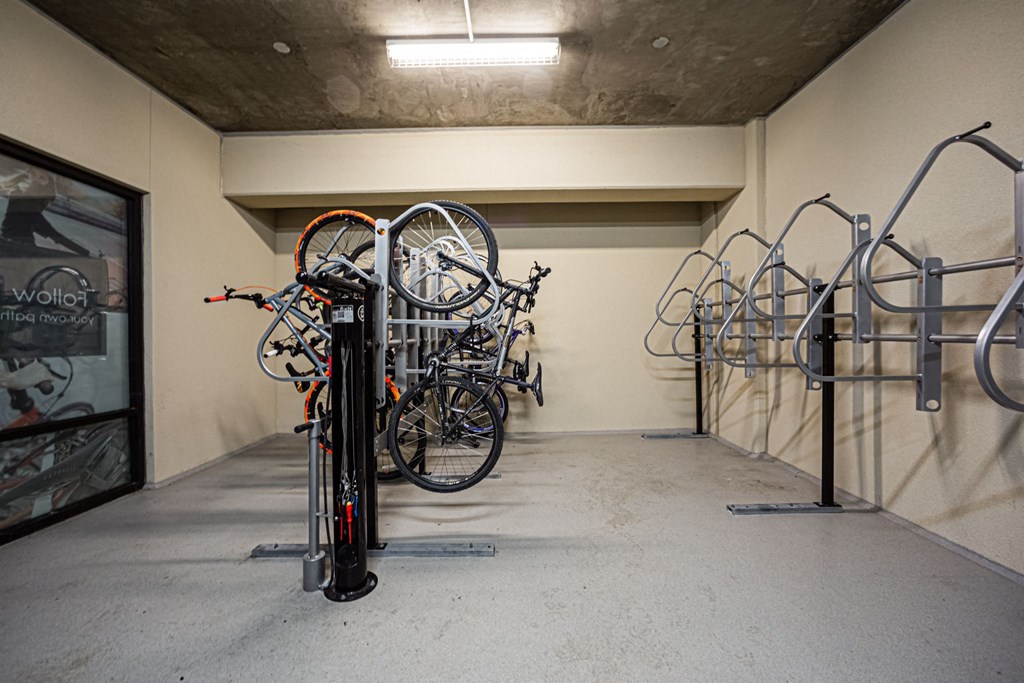 A bike rack with bicycles in a concrete room.