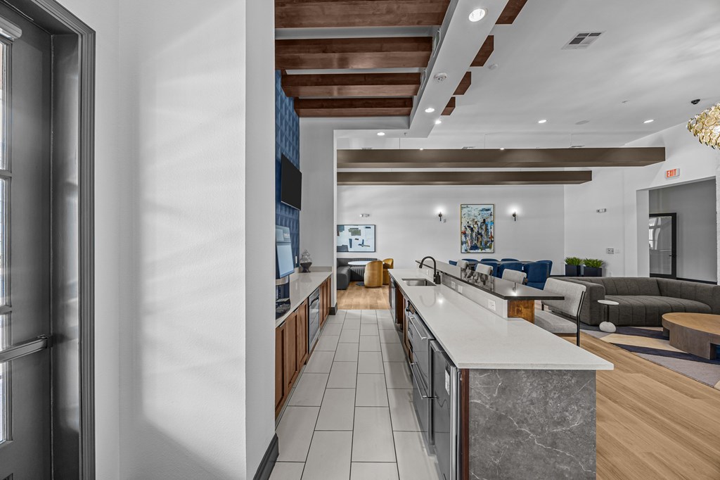 A modern kitchen with a marble countertop and wooden cabinets.