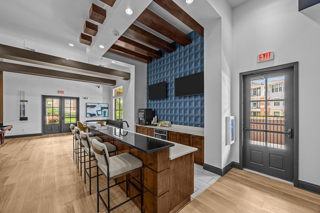 A kitchen with a bar area and chairs.
