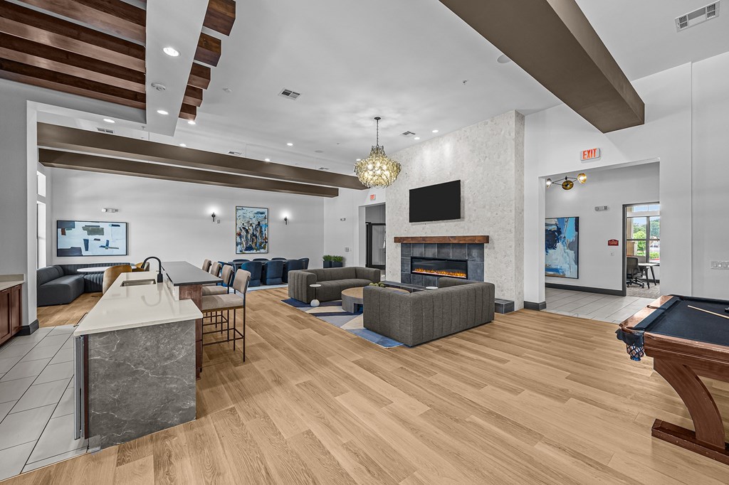 A modern living room with a pool table and a fireplace.