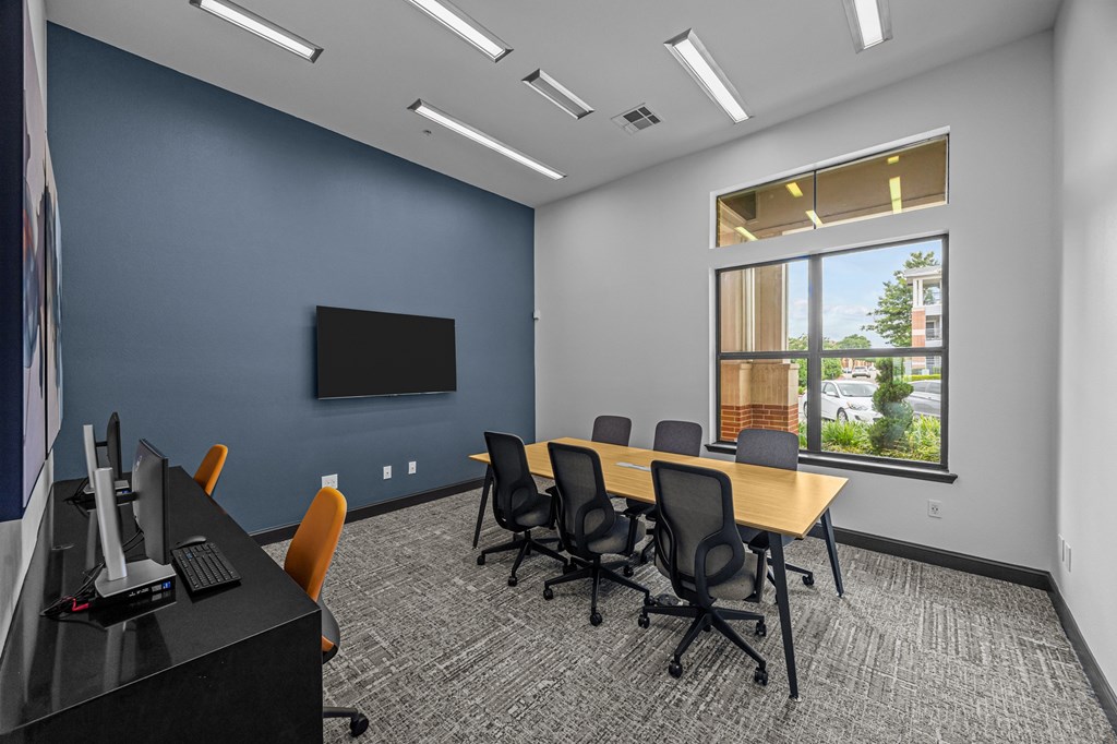 A conference room with a long table and chairs.