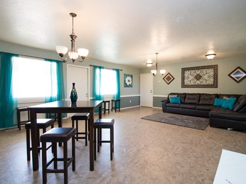 A dining room with a table and chairs.