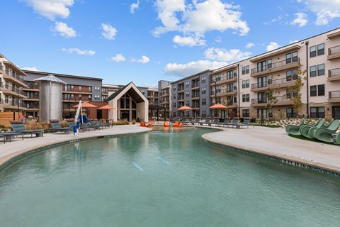 A large swimming pool in front of apartment buildings.