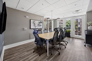 A conference room with a long table and chairs.