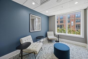 A room with blue walls and a window overlooking a building.