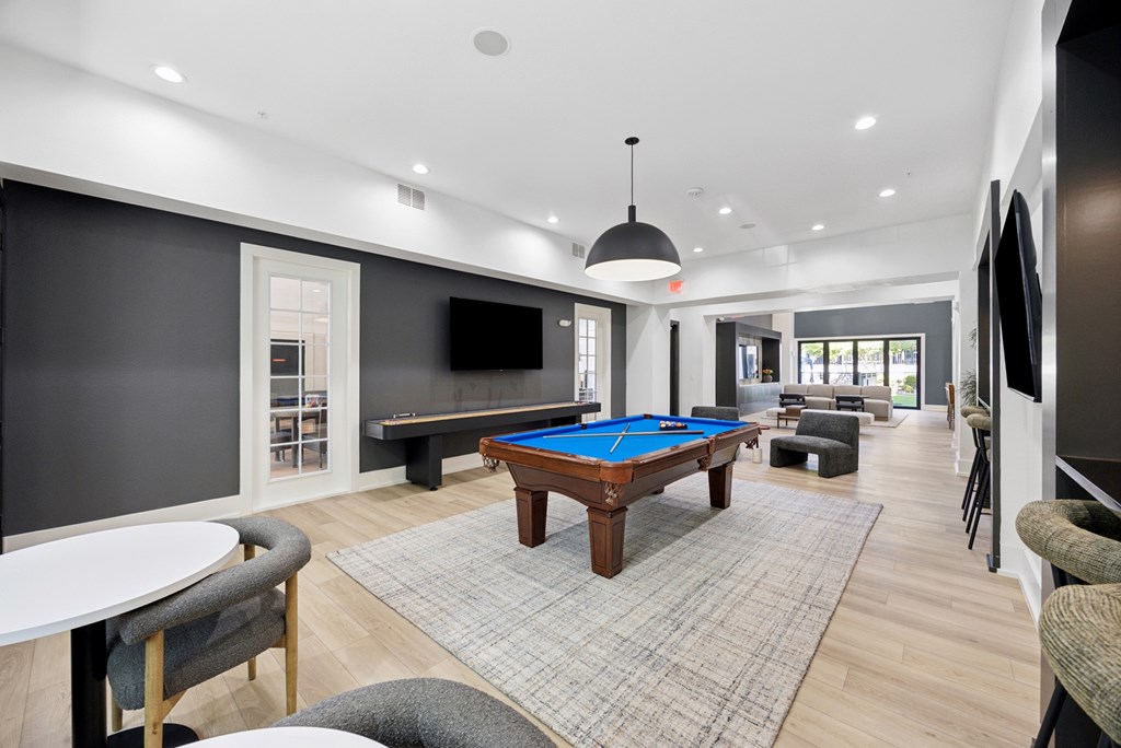 A room with a pool table and a television.
