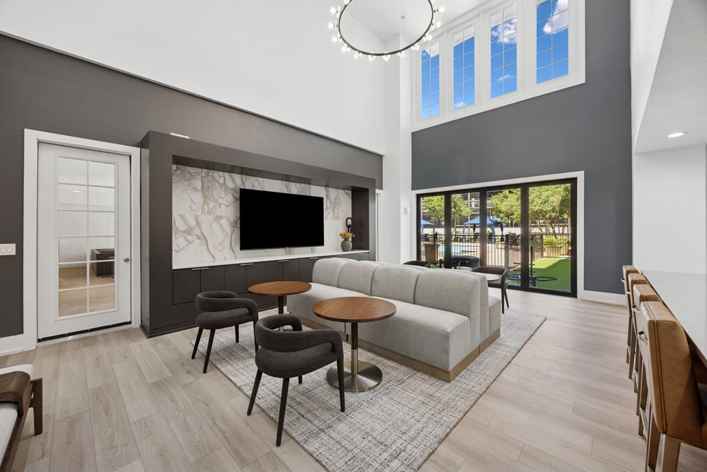 A modern living room with a grey sofa, a round table, and a television.