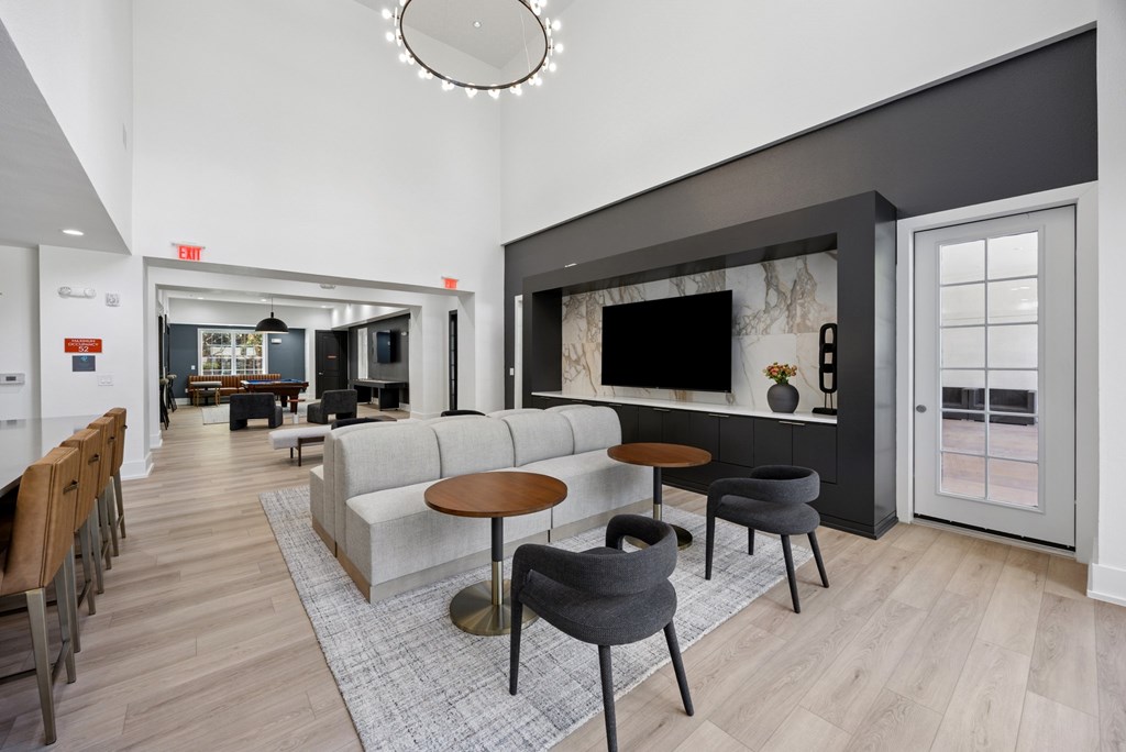 A modern living room with a grey couch, a coffee table, and a TV.