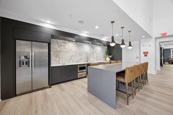 A kitchen with a marble backsplash and wooden floors.