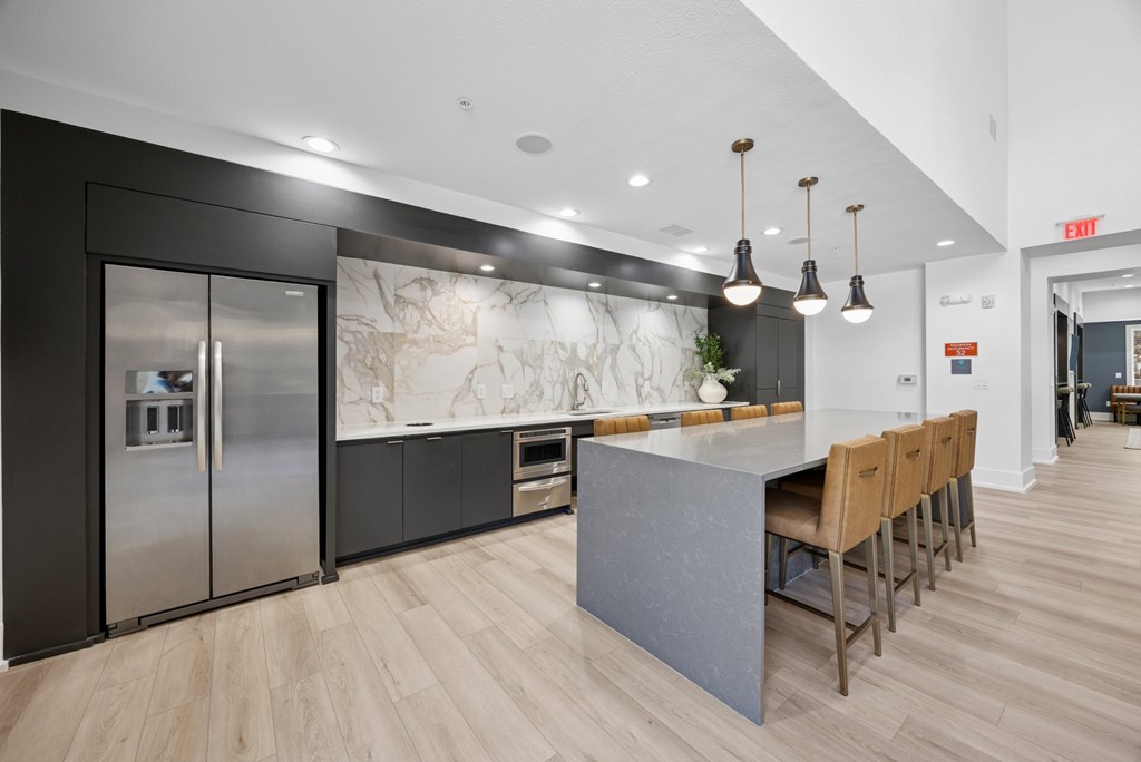 A kitchen with a marble backsplash and wooden floors.