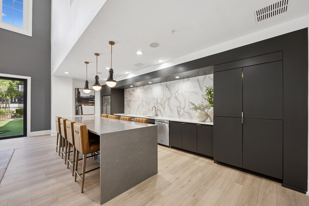 A modern kitchen with a marble backsplash and wooden floors.