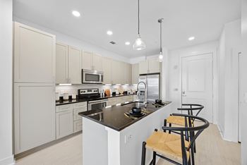 A kitchen with a black counter top and white cabinets.