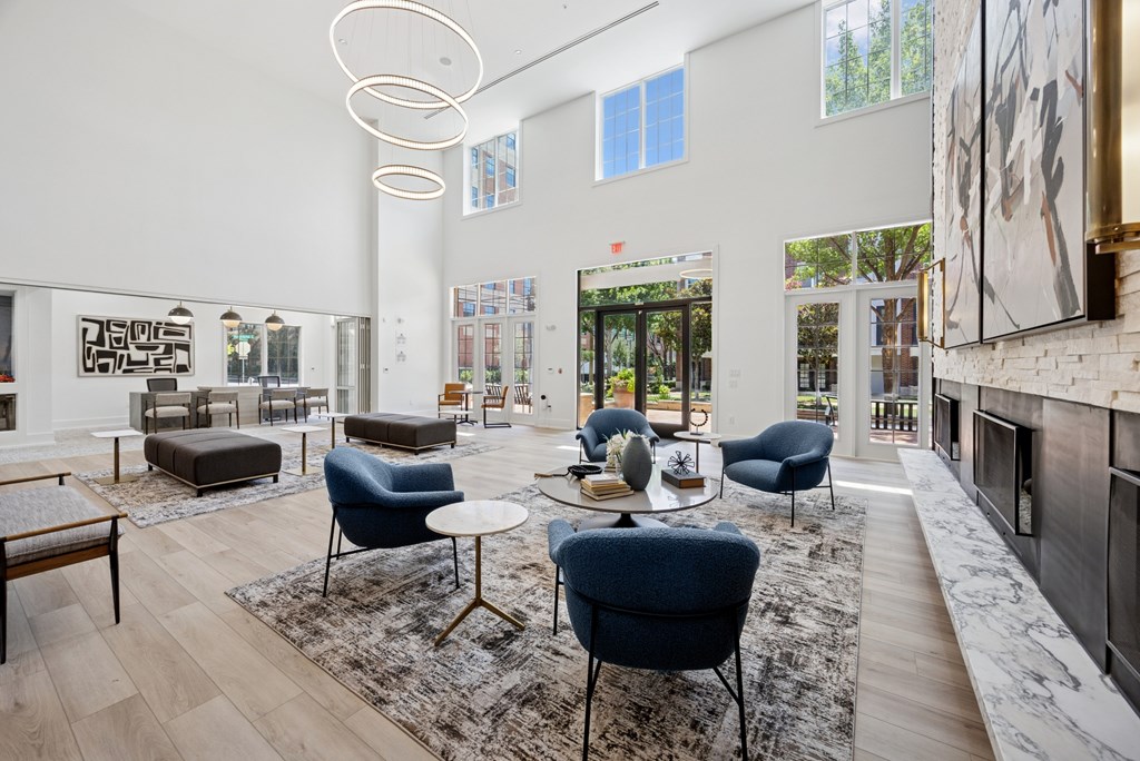 A modern living room with blue chairs and a fireplace.