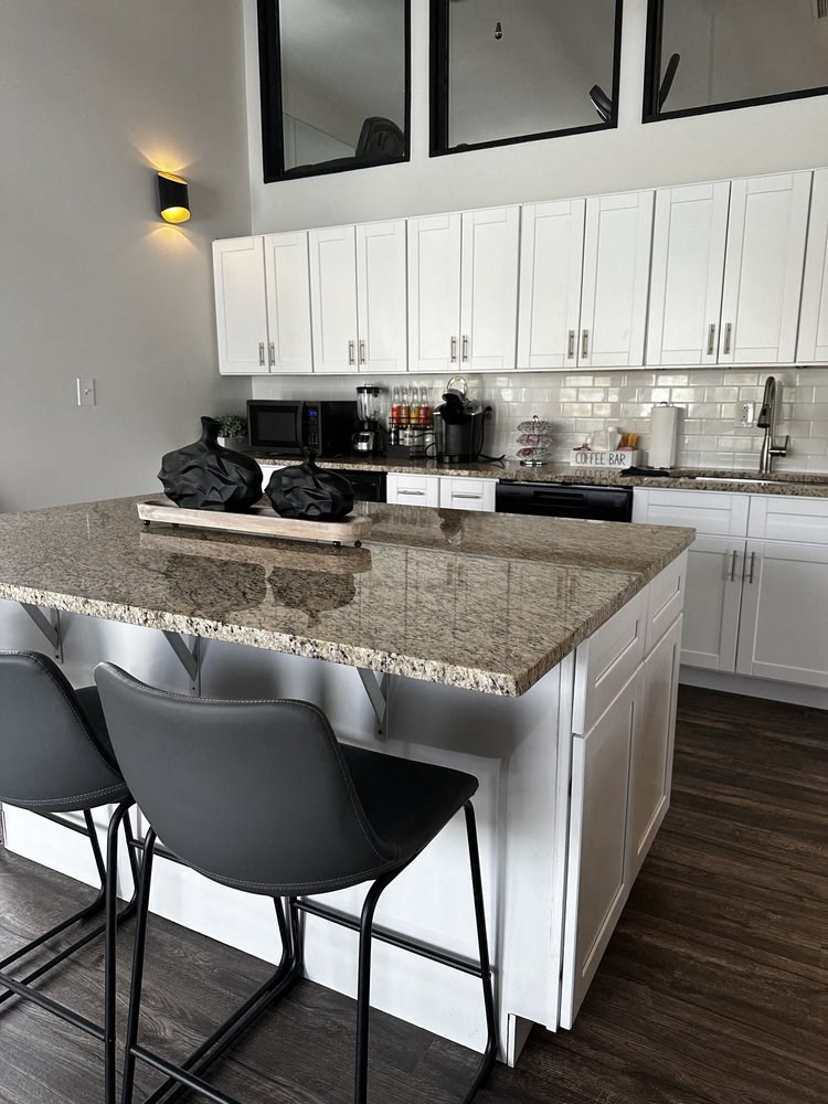 a kitchen with white cabinets and a granite counter top
