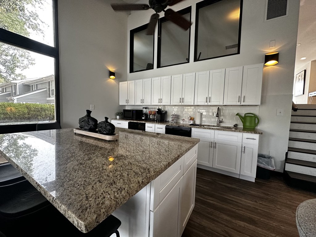 a kitchen with white cabinets and a granite counter top