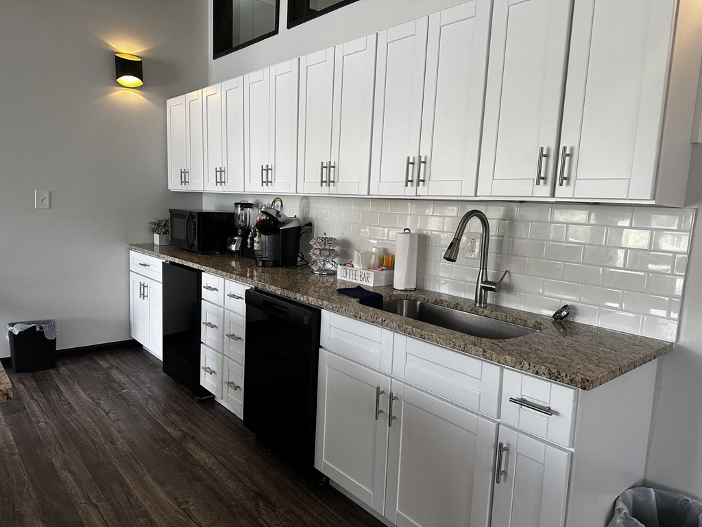 a kitchen with white cabinets and a granite counter top