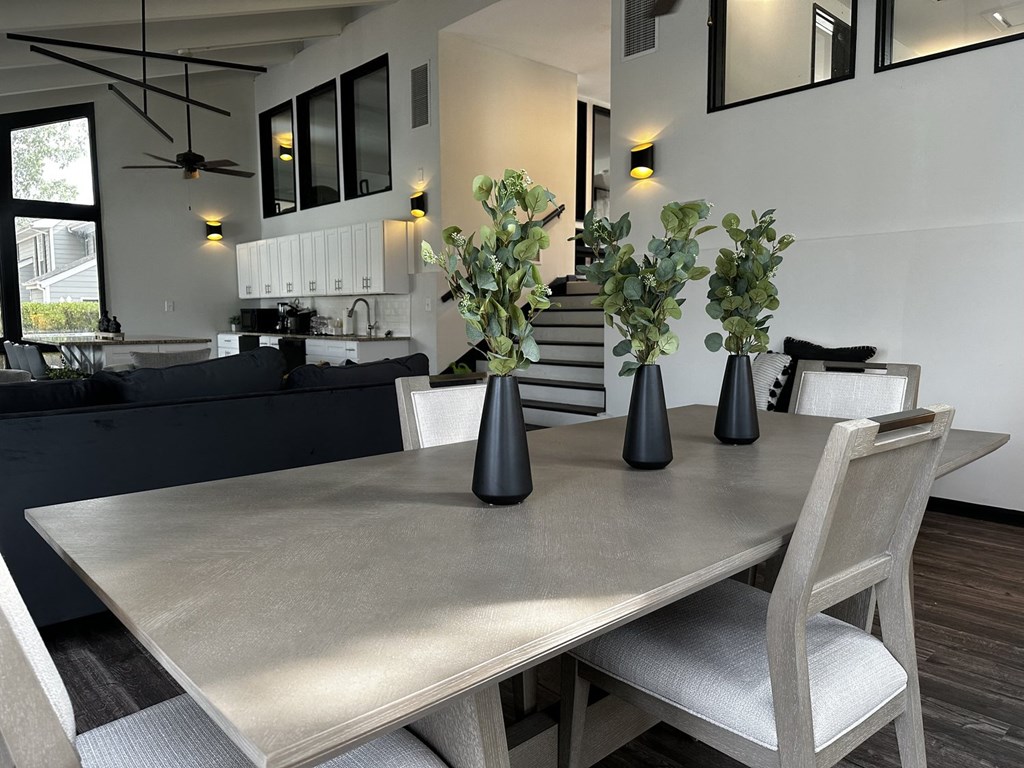 a dining room with a table and chairs and vases
