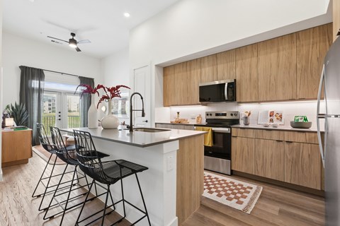 A kitchen with a black counter and chairs.