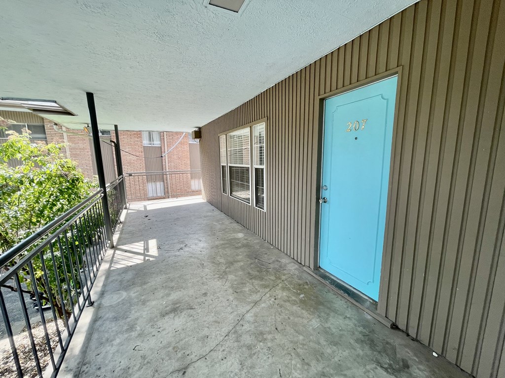 the entrance to a patio with a blue door