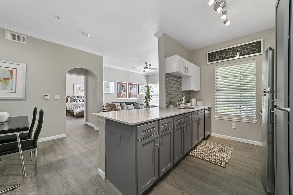 a kitchen with a large island and a dining room in the background