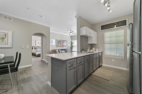 a kitchen with a large island and a dining room in the background