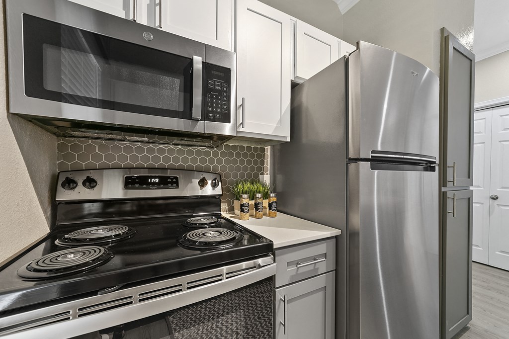 a kitchen with white cabinets and stainless steel appliances