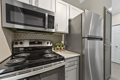 a kitchen with white cabinets and stainless steel appliances