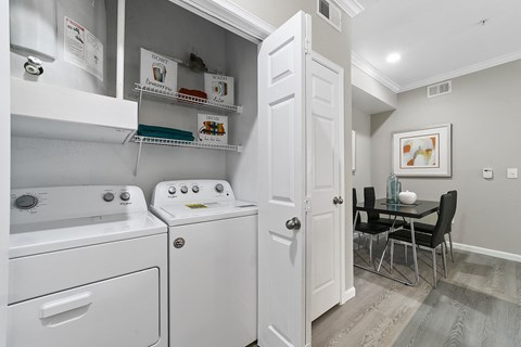 a laundry room with a washer and dryer and a dining room table with chairs