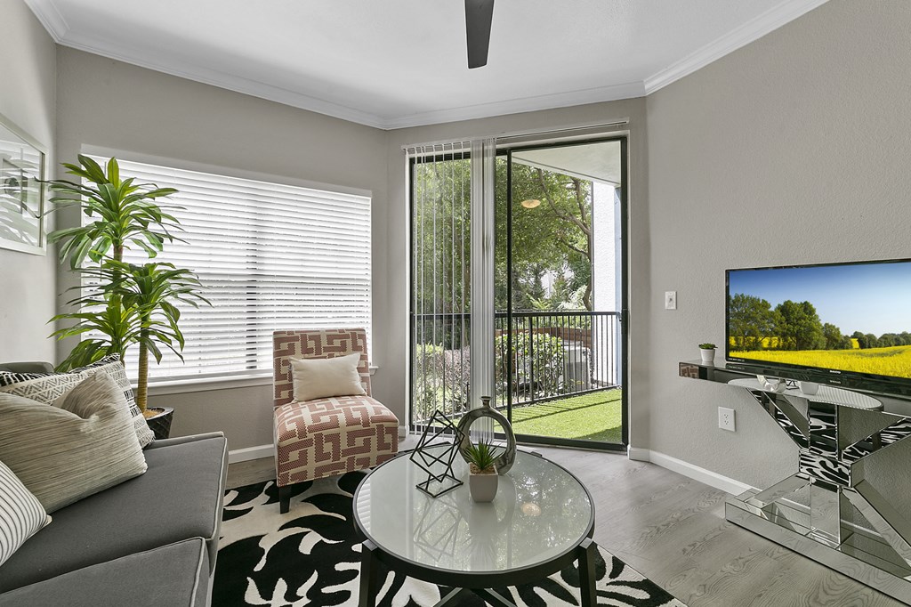 a living room with a sliding glass door leading to a balcony