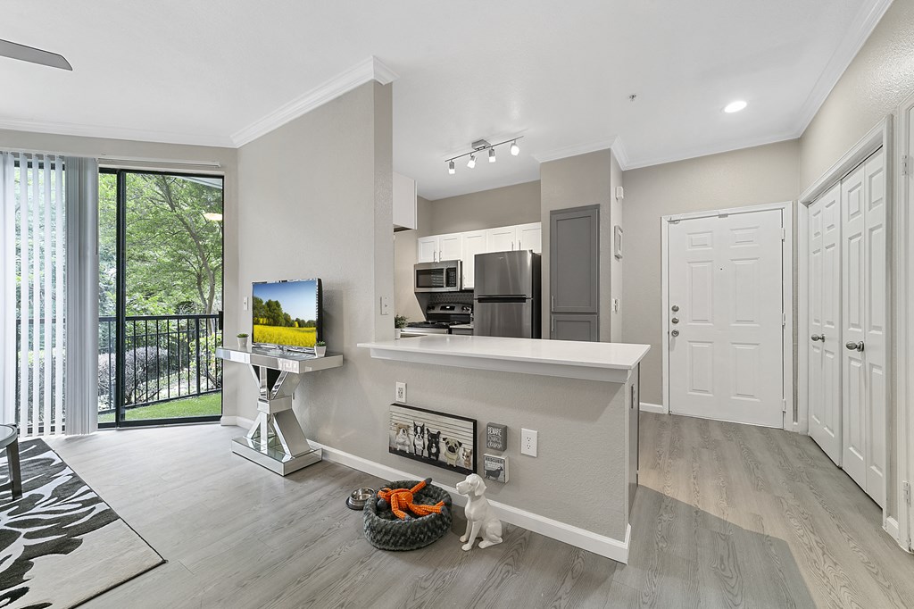 a spacious living room with a kitchen in the background