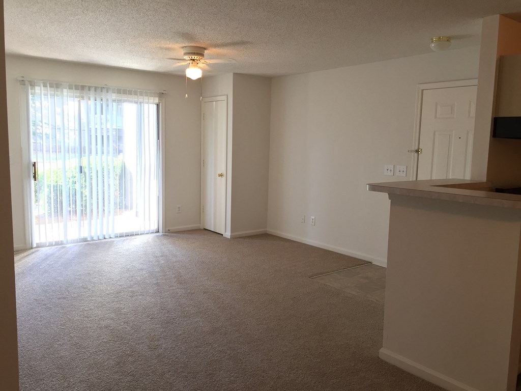 an empty living room with a door to a patio