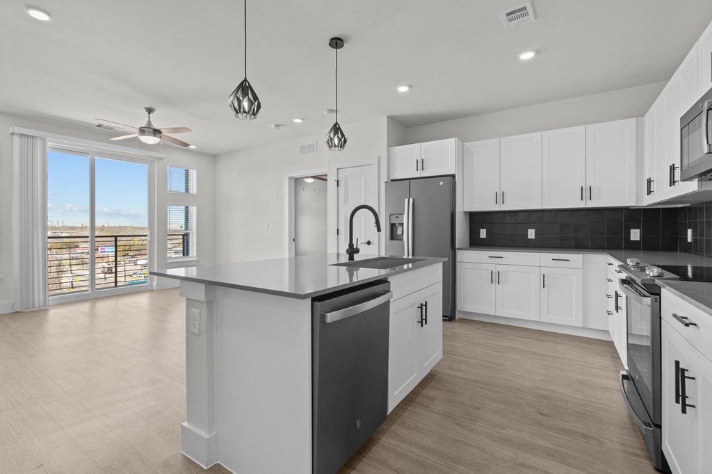 A modern kitchen with white cabinets and a large island.