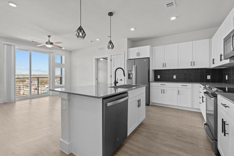 A modern kitchen with white cabinets and a large island.