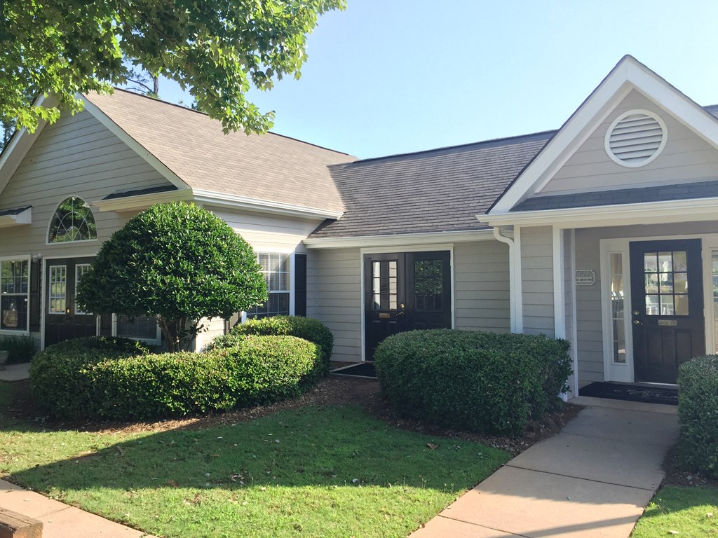 the front of a white house with a sidewalk in front of it