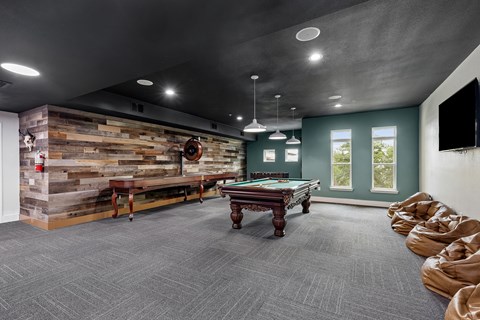 A room with a pool table and a wooden wall.