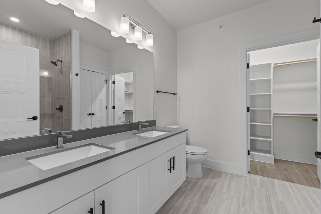 A bathroom with a white sink and a white toilet.