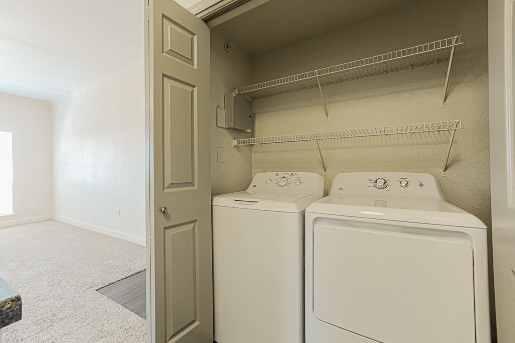 a washer and dryer in a laundry room with a door to the closet