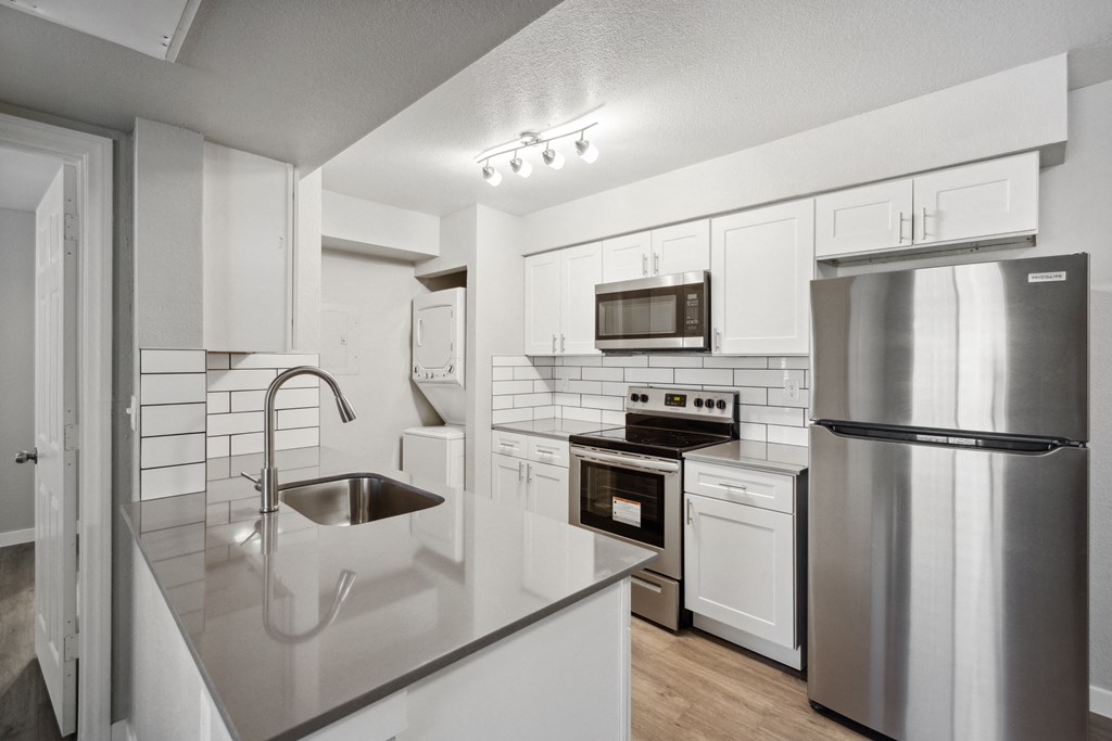 a kitchen with white cabinetry and stainless steel appliances