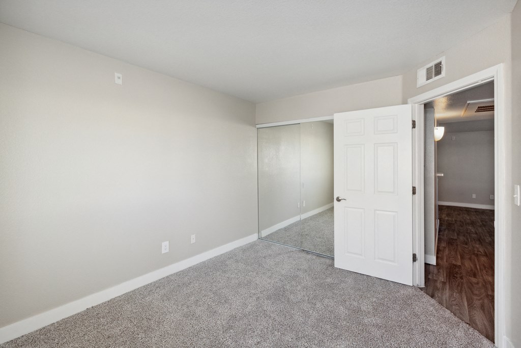 a bedroom with an open door and carpeted flooring